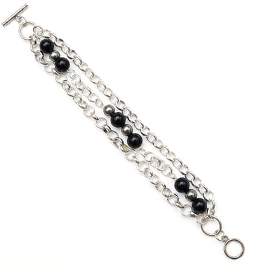 Multi-strand silver chain bracelet featuring black onyx beads and a secure toggle clasp.