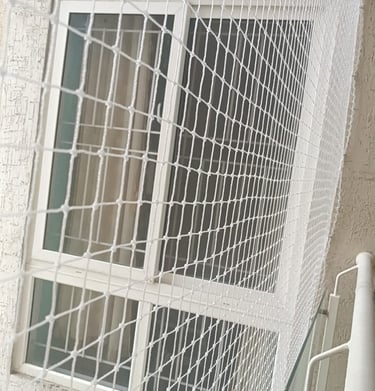 Pet safety netting secured on a window to prevent pets from slipping through gaps.
