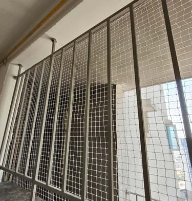 Window protected by a fine mesh pigeon net, ensuring ventilation without bird intrusion.