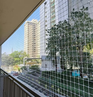 Wide shot of a residential apartment balcony fully covered with pigeon netting to keep birds out.