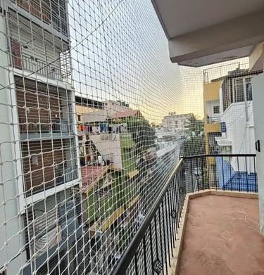 Installation team fitting safety nets on a high-rise balcony in the heart of Pali Hill.