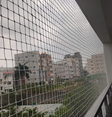 Side view of a balcony showing the neat and seamless fitting of the pigeon net, blending with the bu