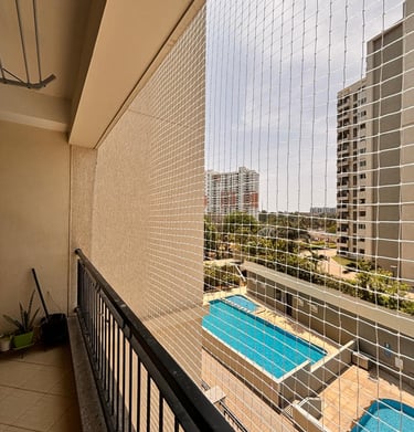 Wide shot showing a spacious balcony fully covered with a neatly fitted safety net.