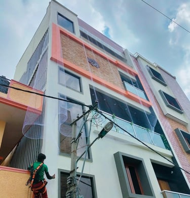 Evening shot of a balcony protected by pigeon nets, with soft city lights in the background.