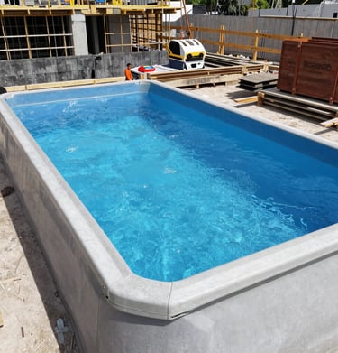 A backyard featuring a newly constructed swimming pool and garden shed.