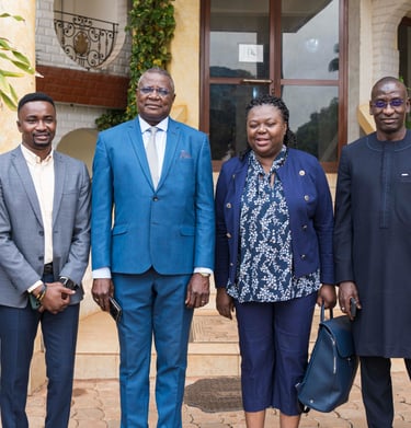 Professional group of African business leaders posing together outdoors in formal attire for a corporate event.