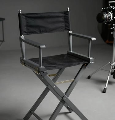 A high-end director's chair and production gear on location in a North American / US setting, charcoal gray metal and deep obsidian black fabric, cinematic aesthetic.