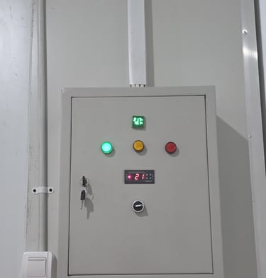 Industrial electrical control panel with digital temperature display and indicator lights.