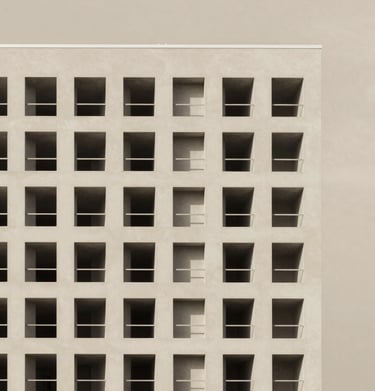 Exterior shot of a modern building showcasing geometric shapes in white and beige against a clear sky.