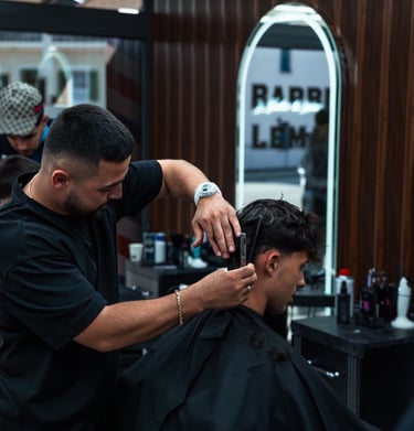 a man getting his hair cut by a barber