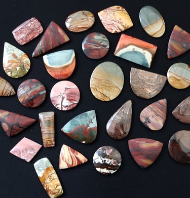 a large selection of hand cut scenic jasper cabochons in a variety of shapes