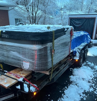 A hot tub and lumber loaded on a large trailer for delivery