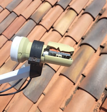 A broken dstv lnb  mounted on a satellite dish on a rooftop