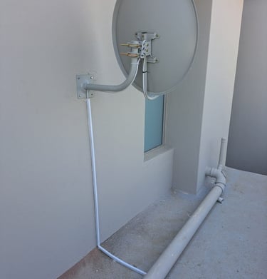 A beautiful dstv dish installed with the cables covered in a conduit pipe