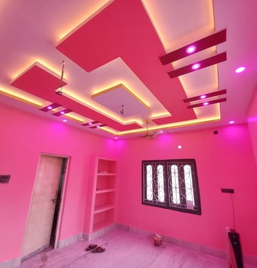 Modern pink bedroom interior featuring a vibrant false ceiling design with cove lighting and LED spotlights.