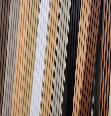 A variety of fluted wall panel samples in various wood tones and neutral colors for interior design.