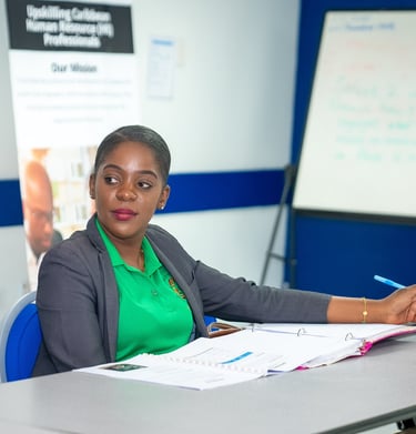 a woman in a green shirt and a white shirt listening intently to a presentation