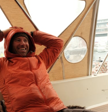 arctos guide sitting on a boat smiling | ski and sail in Norway