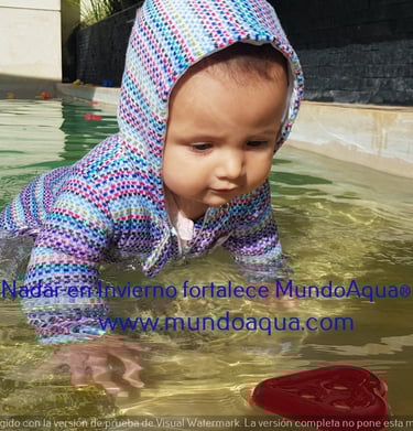 a baby in a pool with a frisbee in the water