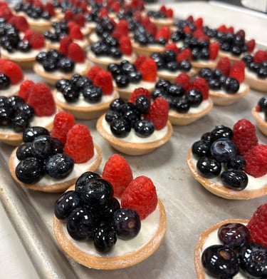 Mini fruit tarts with fresh blueberries and raspberries on vanilla cream filling.