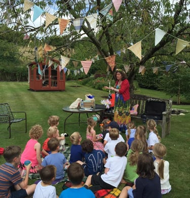 The children sit around listening attentively to a storytelling session