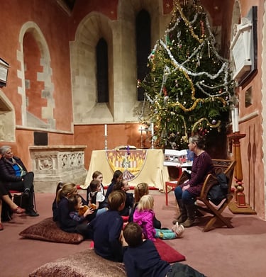 Children sit around the biggest Christmas Tree to hear stories