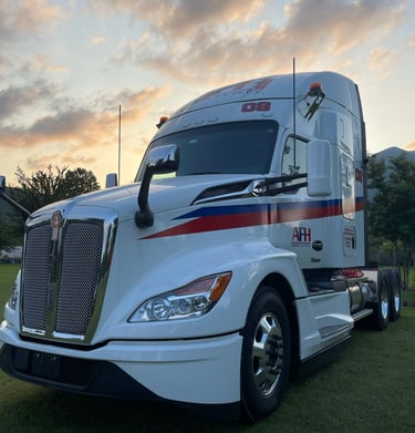 Tractocamión AFH Logistics bajo un cielo al atardecer, listo para carga