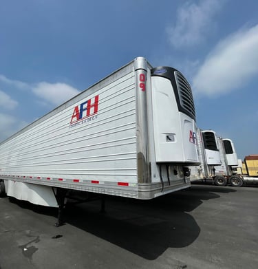 Remolque refrigerado AFH Logistics vacío en un estacionamiento industrial