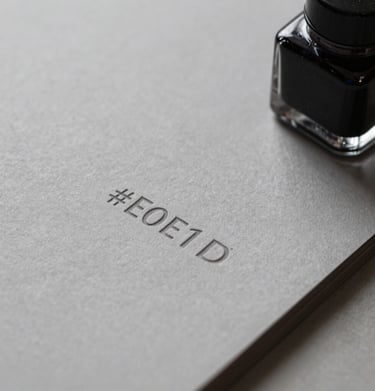 Close up of luxury stationery with embossed logo details. The lighting is focused and dramatic, highlighting the quality of the #E0E1DD paper and #0D1B2A ink.