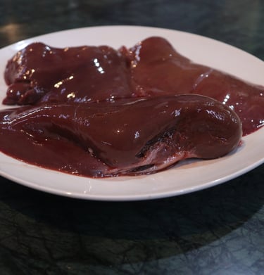 a plate of liver with a piece of meat on it