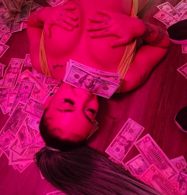 a woman laying on a table with money bills