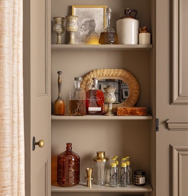 a cabinet with a shelf full of bottles and bottles