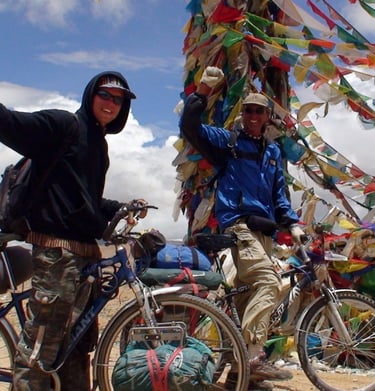 two cyclists at a Tibetan pass