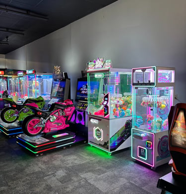 Indoor arcade with motorcycle racing games and claw machine prize games for entertainment.