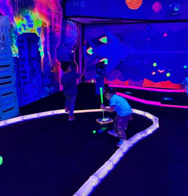 Kids playing glow-in-the-dark mini golf at Yum Yum Fun birthday party, Plymouth PA