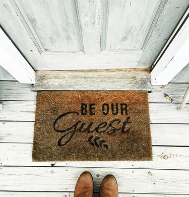 Felpudo "Sé mi invitado" delante de la puerta