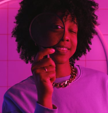 Una niña sostiene una lupa delante de su cara.