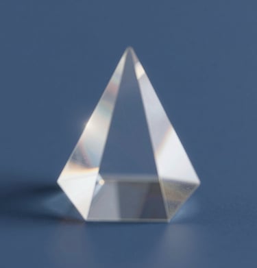 Abstract shot of light refracting through a crystal prism, creating soft flares of #F2F5F7 against a deep blue #4A616F background.