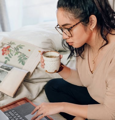 woman drinking tea in front of computer