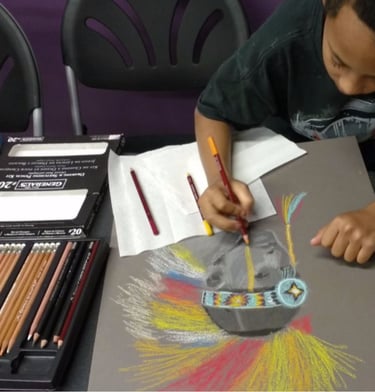 a young boy is drawing a colorful picture of a native american