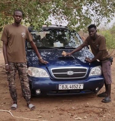 Teamleden van Birding Adventures Gambia & Senegal poseren bij een blauwe Kia safari-auto, gebruikt v