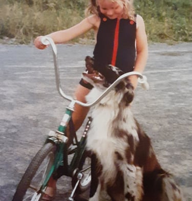 Image of girl on bike with a dog.