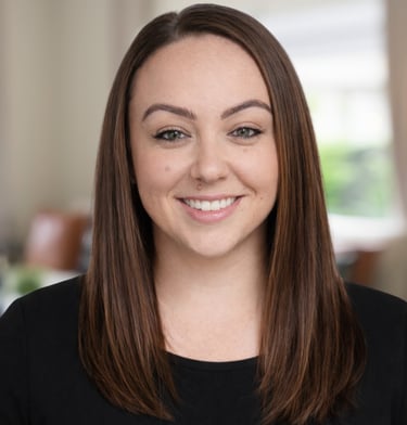 Professional headshot of a smiling woman with straight brown hair wearing a black top.