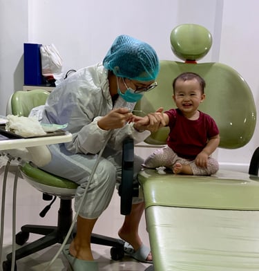 a woman in a surgical mask and a baby in a chair