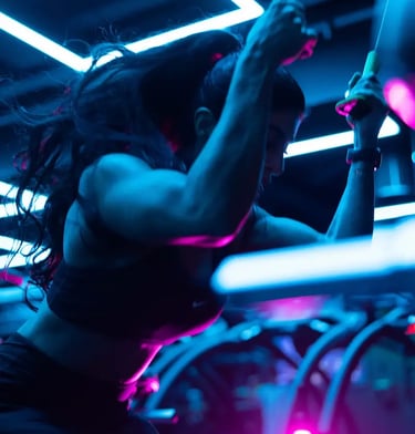 mais alhajri performing cable workout under neon gym lights , showcasing strength and fitness