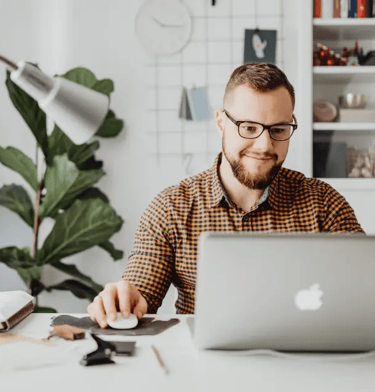 man in yellow shirt at laptop
