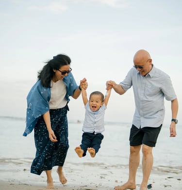 Parents lifting their son while enjoying a playful moment during a family photography session at Nusa Dua Beach Bali