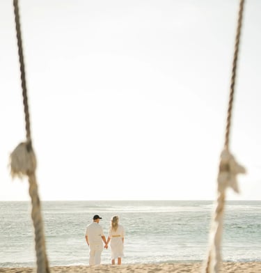 Family framed by a beach swing during a family photography session at Ayodya Resort Bali in Nusa Dua