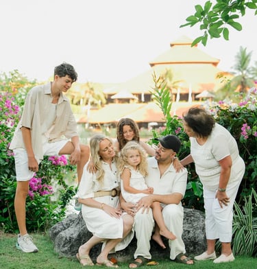 Family portrait surrounded by tropical gardens during a photography session at Ayodya Resort Bali in Nusa Dua