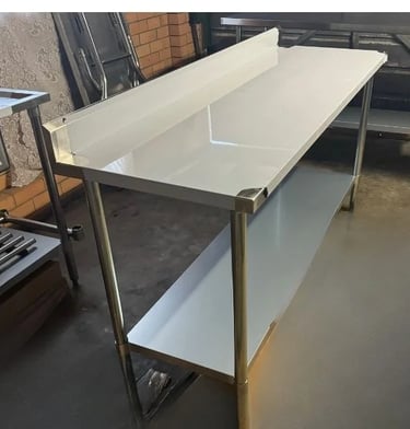 Large stainless steel prep table with splashback and under shelf, available for table hire.